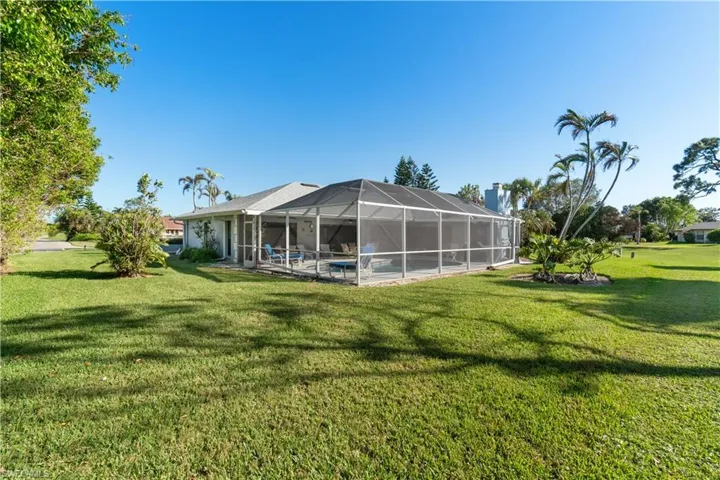 Rear view of house with a lawn and a lanai