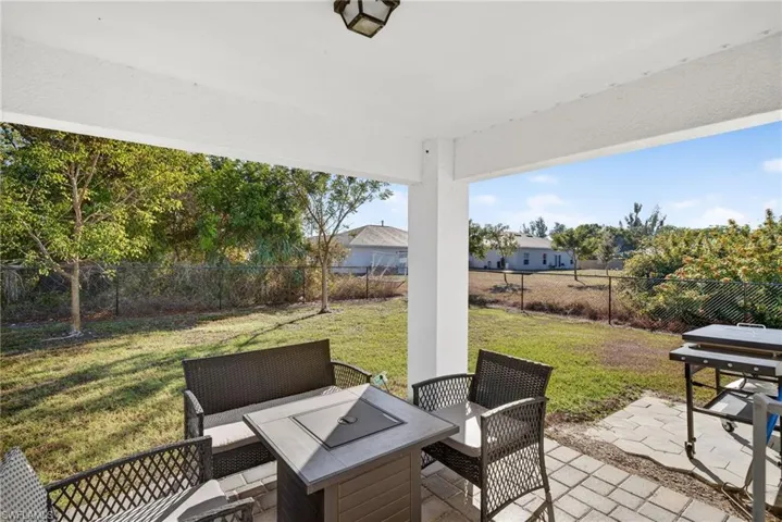 Fenced backyard featuring a patio, an outdoor living space, and area for grilling