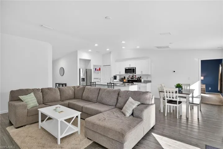 Living area with vaulted ceiling and light wood finished floors