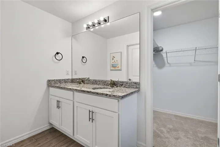 Full bath featuring a walk in closet and double vanity