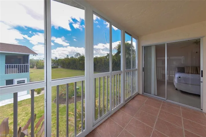 View from Covered and screened Lanai. Features large tile flooring and sliding windows for year round enjoyment. Shows sliding glass doors to Primary bedroom suite.