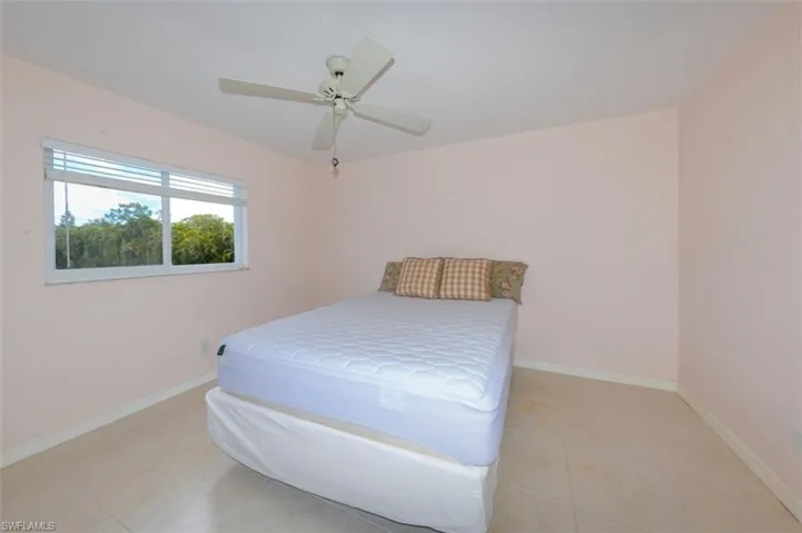 Primary bedroom suite with large tile flooring and updated window.