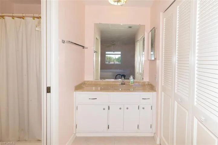 Primary bedroom suite bathroom with door to shower and commode on left and closet on right.