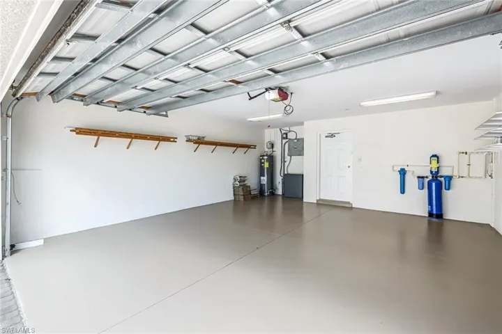 Garage featuring water heater and a garage door opener