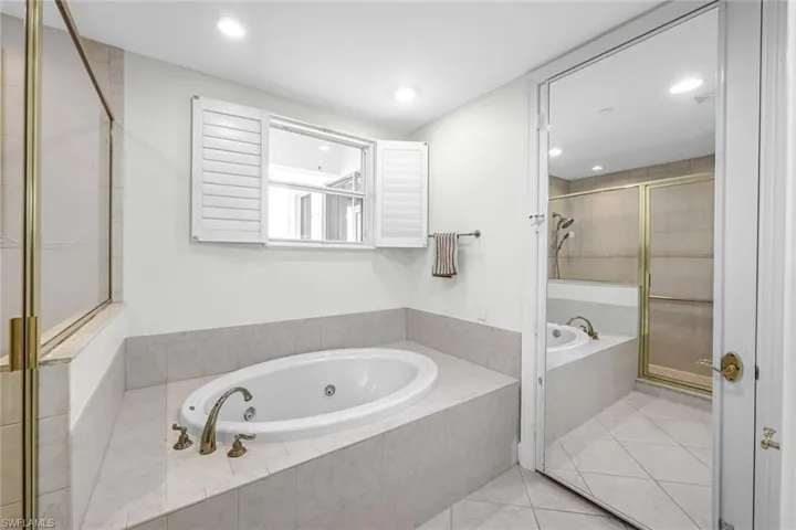 Bathroom with a garden tub, a shower stall, light tile patterned floors, and recessed lighting