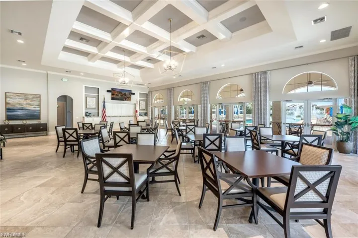 Dining room featuring coffered ceiling, a high ceiling, arched walkways, beam ceiling, and healthy amount of natural light