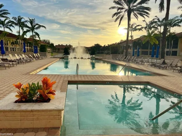 Pool at dusk with a patio area and a community pool