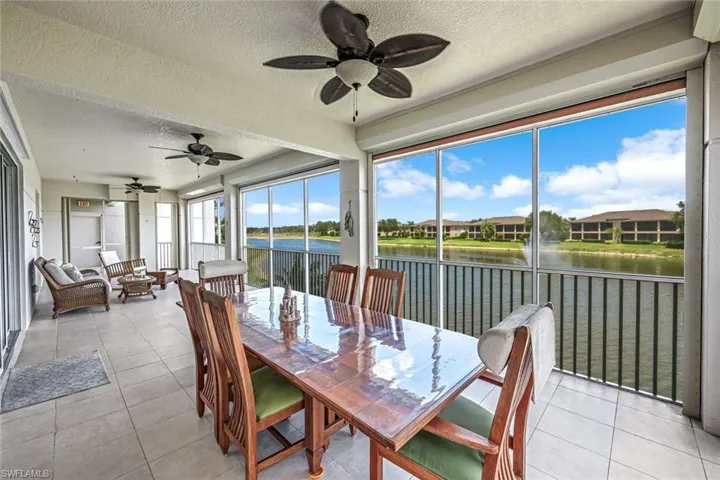 Sunroom featuring a textured ceiling, tile patterned flooring, and a water view