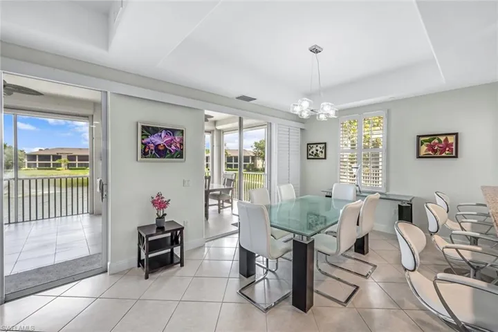 Dining area with tile patterned flooring, a chandelier, and a raised ceiling