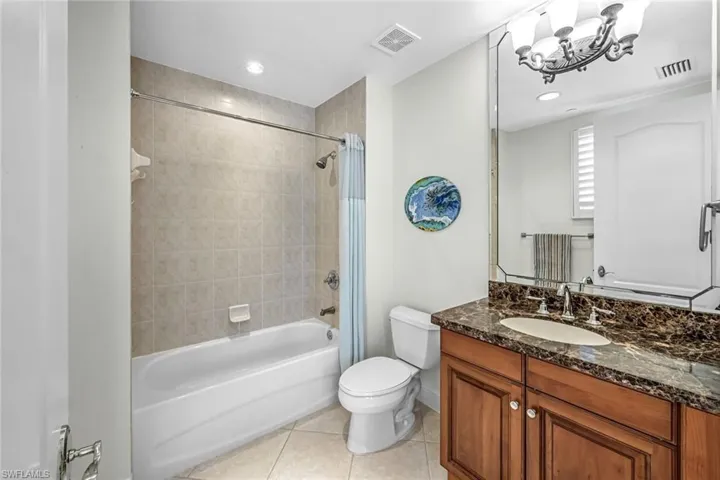 Bathroom with light tile patterned flooring, tub / shower combination, vanity, a chandelier, and recessed lighting