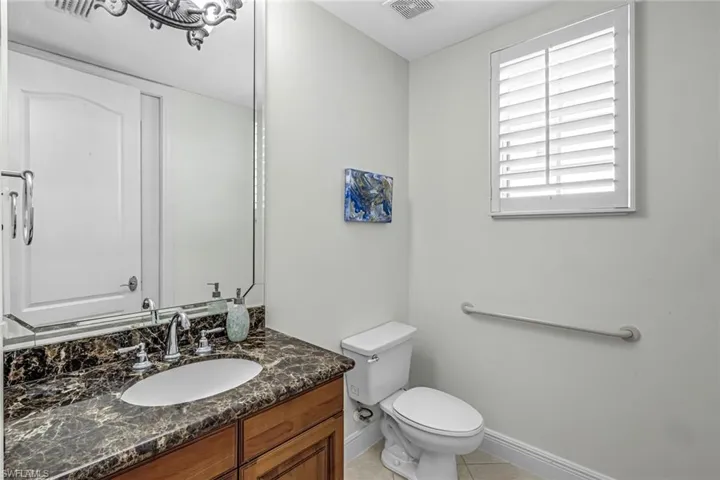 Half bath with vanity and light tile patterned flooring