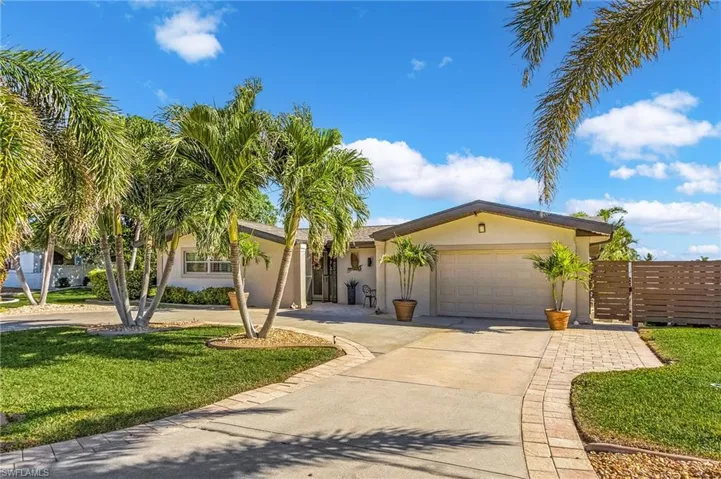 Ranch-style house featuring a garage and a front yard
