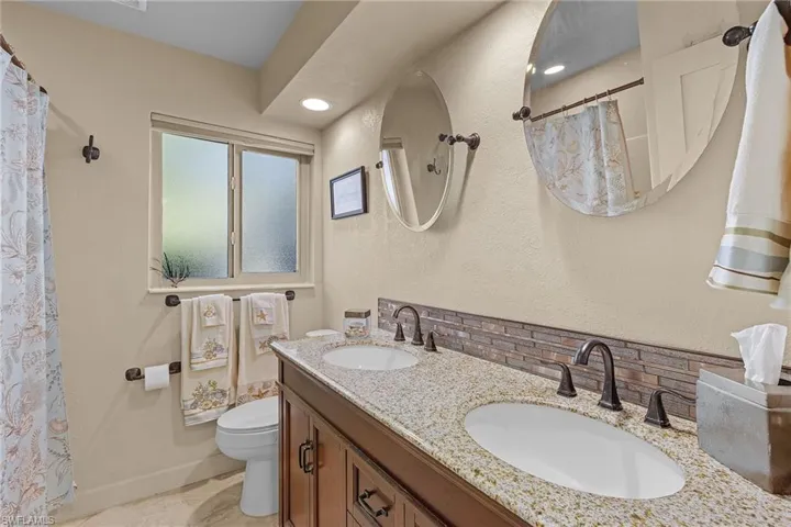 Bathroom featuring backsplash, vanity, and toilet