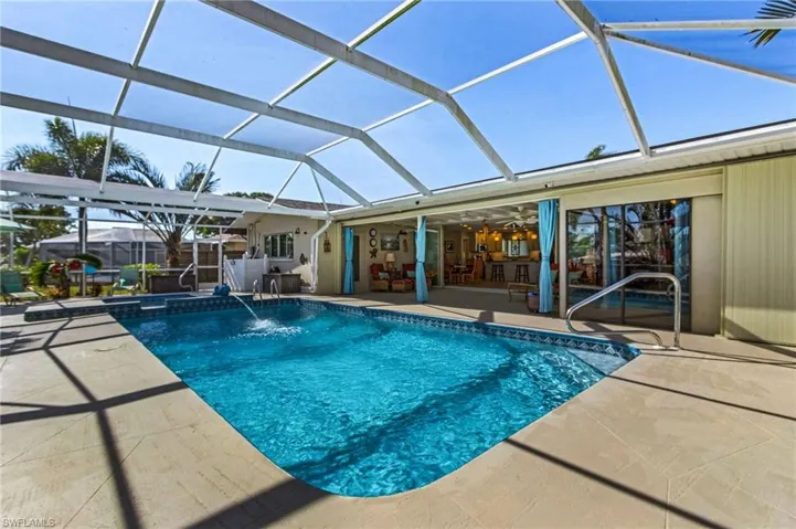 View of pool featuring pool water feature, a patio, and a lanai