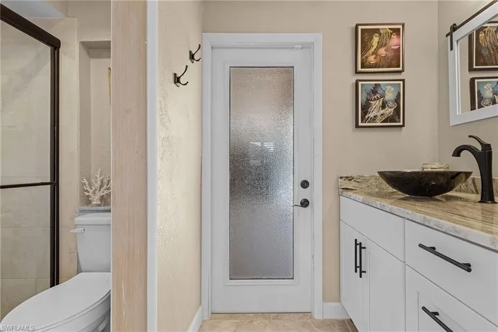 Bathroom featuring tile patterned floors, vanity, toilet, and walk in shower