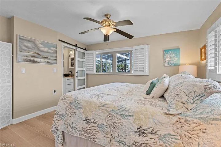 Bedroom with a barn door and ceiling fan