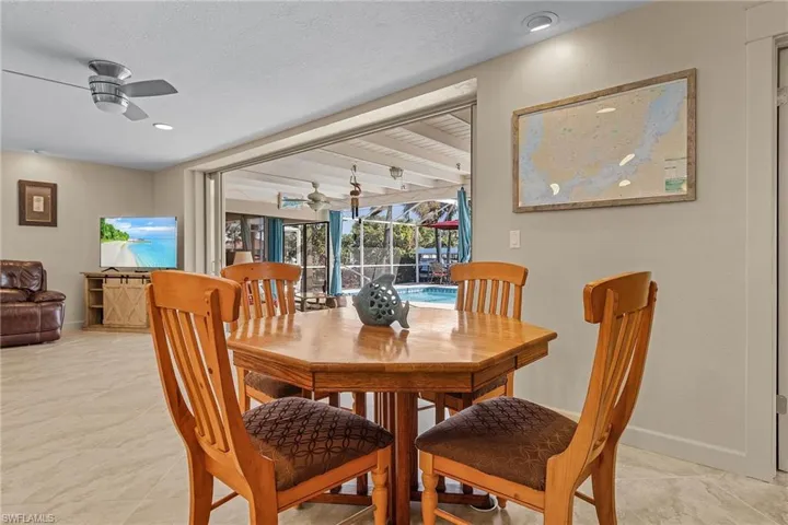 Dining space featuring beamed ceiling, a textured ceiling, and ceiling fan