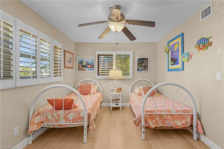 Bedroom featuring multiple windows, ceiling fan, and hardwood / wood-style floors