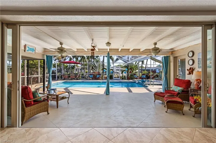 View of pool featuring glass enclosure and a patio
