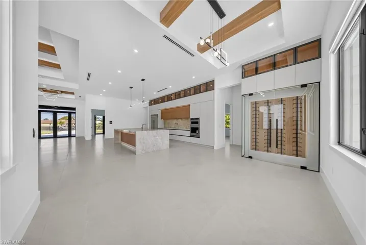 Unfurnished living room featuring a high ceiling, recessed lighting, and concrete flooring