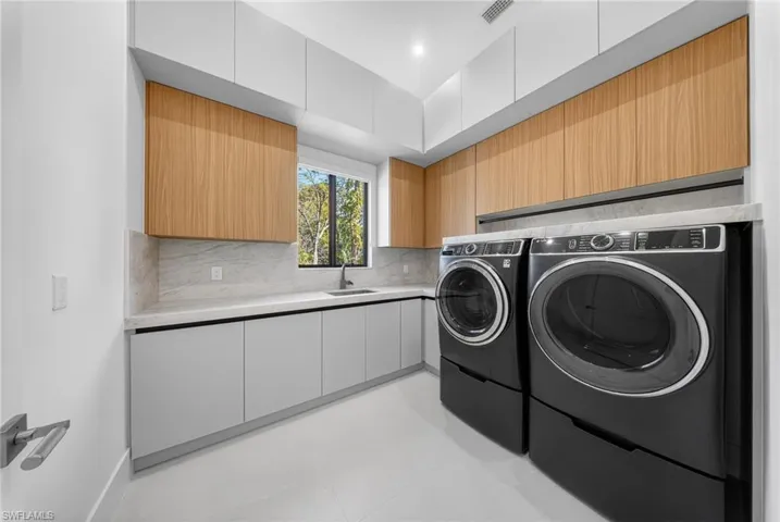 Laundry area with cabinet space and washing machine and dryer