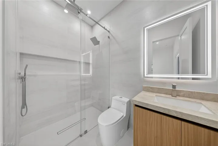 Full bathroom with vanity and a stall shower