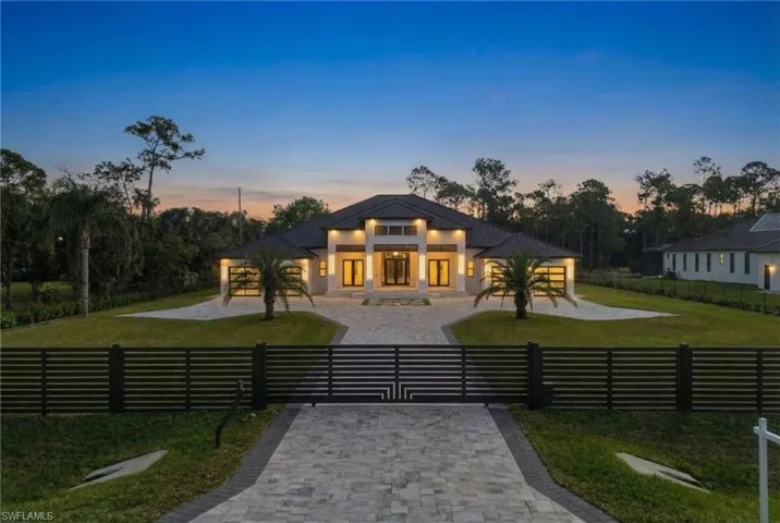 Contemporary house featuring a gate, a fenced front yard, driveway, a patio area, and stucco siding