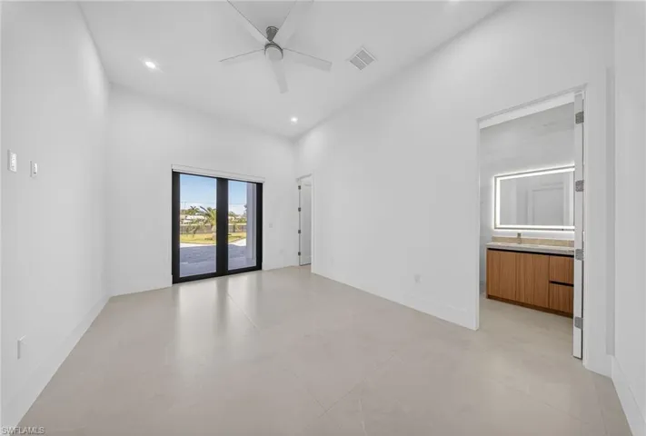 Unfurnished room featuring a high ceiling, a ceiling fan, and recessed lighting