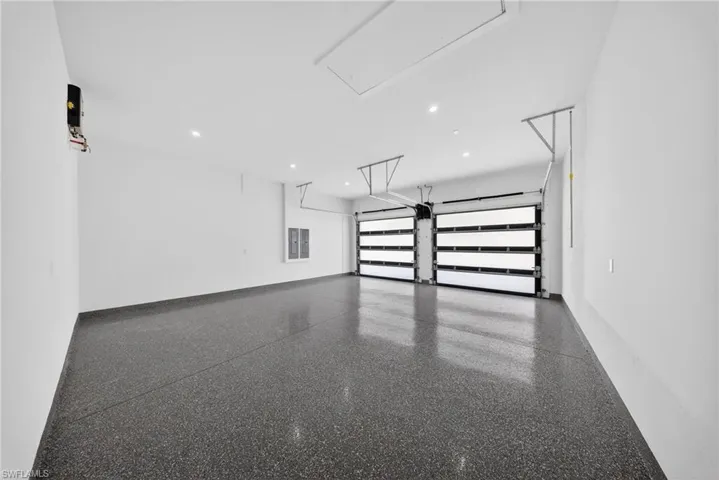 Garage featuring recessed lighting and electric panel
