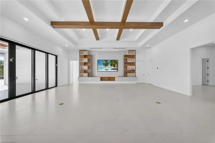 Unfurnished living room featuring coffered ceiling and recessed lighting