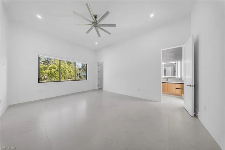 Unfurnished room with a ceiling fan, a high ceiling, and recessed lighting