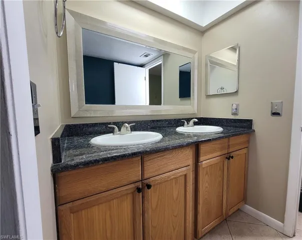 Bathroom with tile floors and double sink vanity