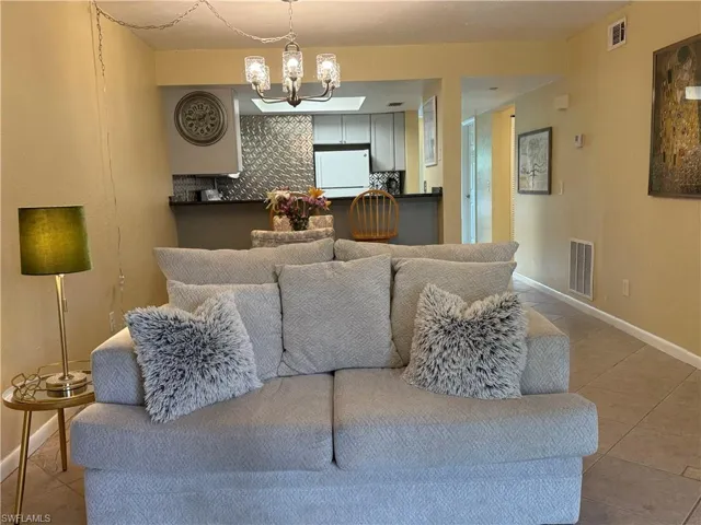 Tiled living room featuring a chandelier