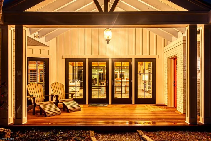View of exterior entry featuring board and batten siding and a deck