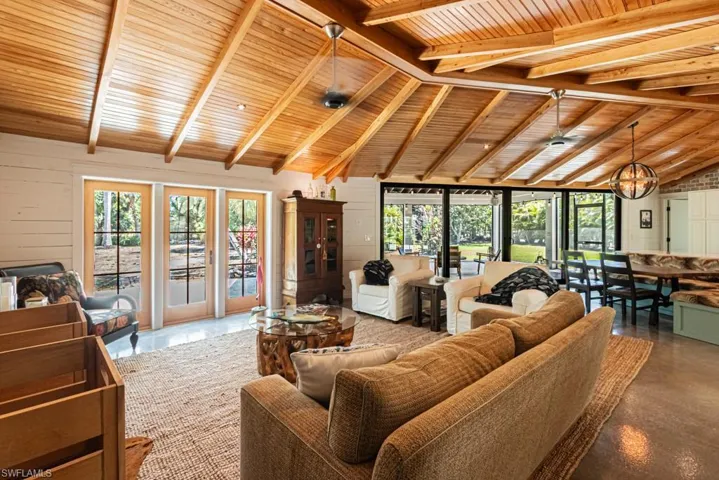 Living room featuring wooden ceiling, plenty of natural light, a chandelier, and finished concrete flooring