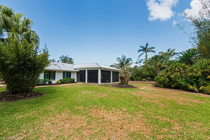 View of green lawn with a sunroom