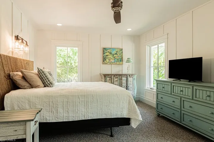 Bedroom featuring a decorative wall, dark colored carpet, ceiling fan, and recessed lighting