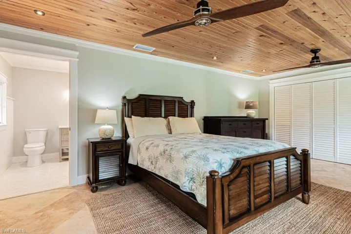 Bedroom featuring wood ceiling, a closet, a ceiling fan, crown molding, and ensuite bathroom