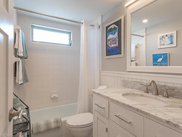 Bathroom featuring vanity, a wainscoted wall, and shower / bath combo