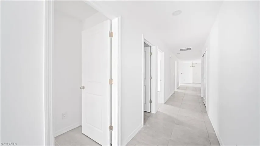 Hall with baseboards and light tile patterned floors
