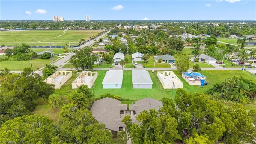 View of property location featuring a tree filled landscape and nearby suburban area