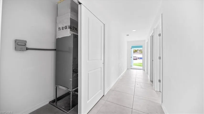 Corridor featuring light tile patterned floors and recessed lighting