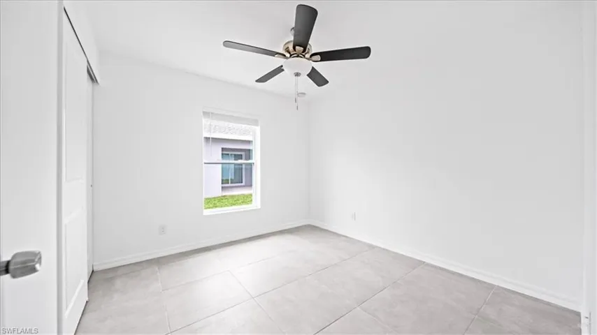 Spare room with light tile patterned floors and a ceiling fan
