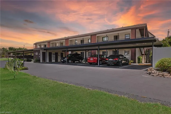 View of front facade featuring a yard and a carport