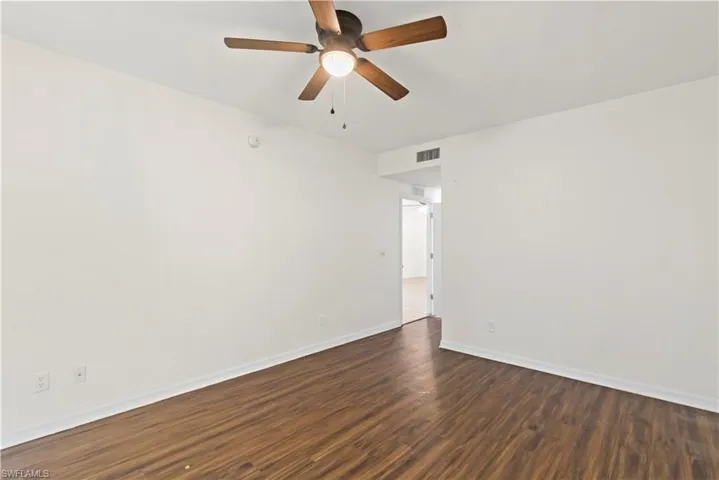 Spare room with ceiling fan and wood-type flooring
