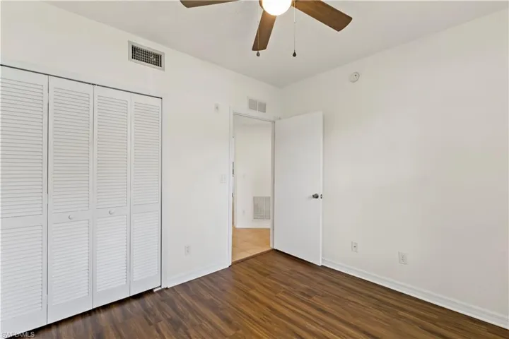 Unfurnished bedroom featuring ceiling fan, wood-type flooring, and a closet