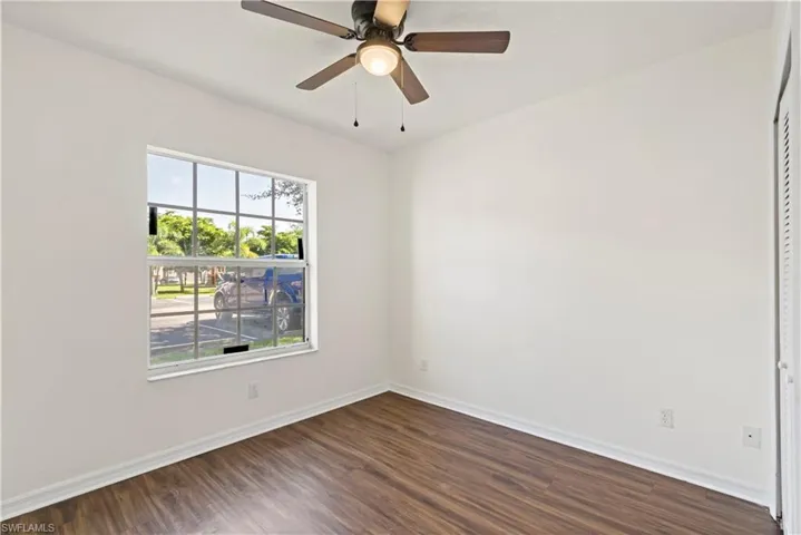 Unfurnished room with ceiling fan and dark wood-type flooring