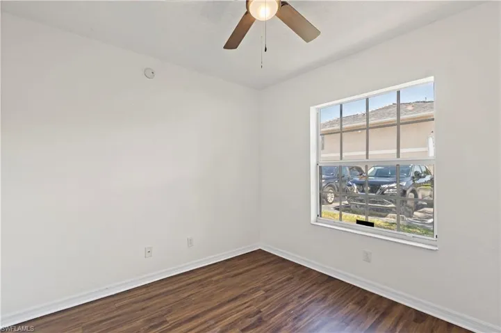 Unfurnished room with ceiling fan, a healthy amount of sunlight, and hardwood / wood-style flooring