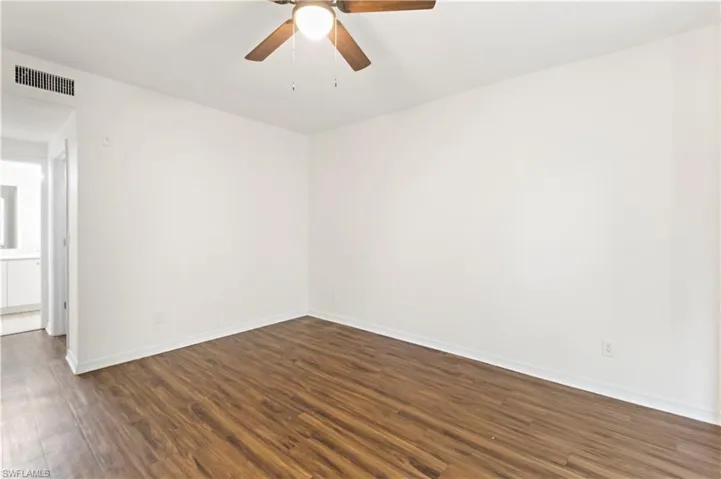 Empty room with ceiling fan and hardwood / wood-style flooring