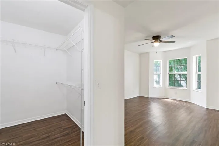 Spacious closet with ceiling fan and wood-type flooring